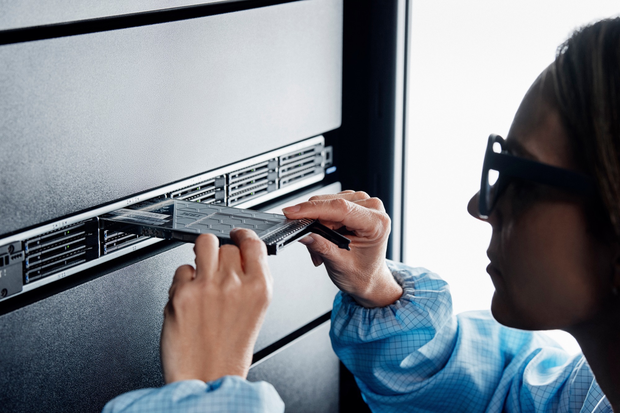 A technician installs an IBM FlashCore module in a storage rack